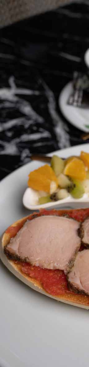 Tostada con tomate y carne acompañada de fruta