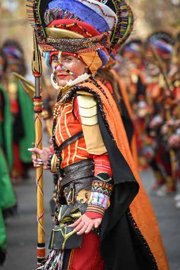 Comparsa con trajes y plumas en el desfile